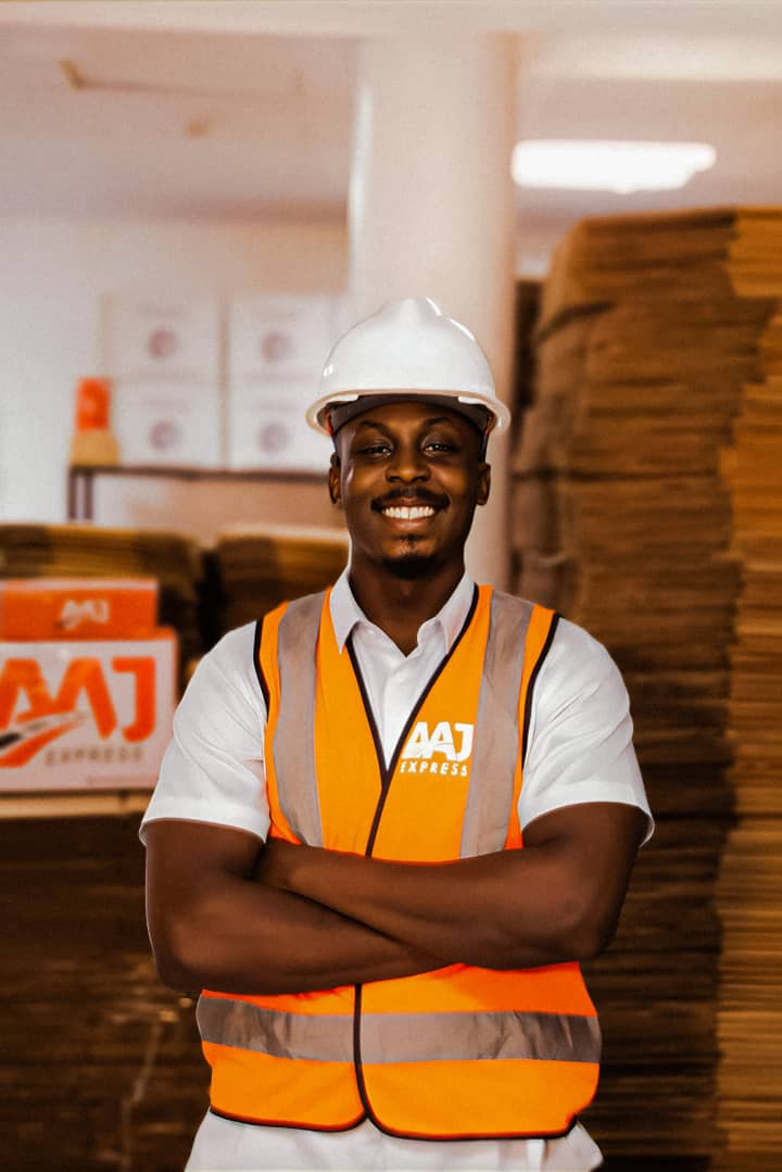 AAJ Express logistics worker in safety gear with crossed arms in warehouse